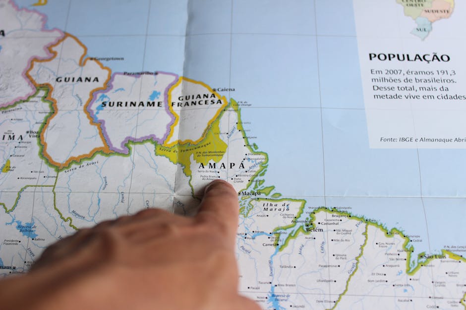 Close-up of a finger pointing at Amapá on a map of Brazil, highlighting geography.